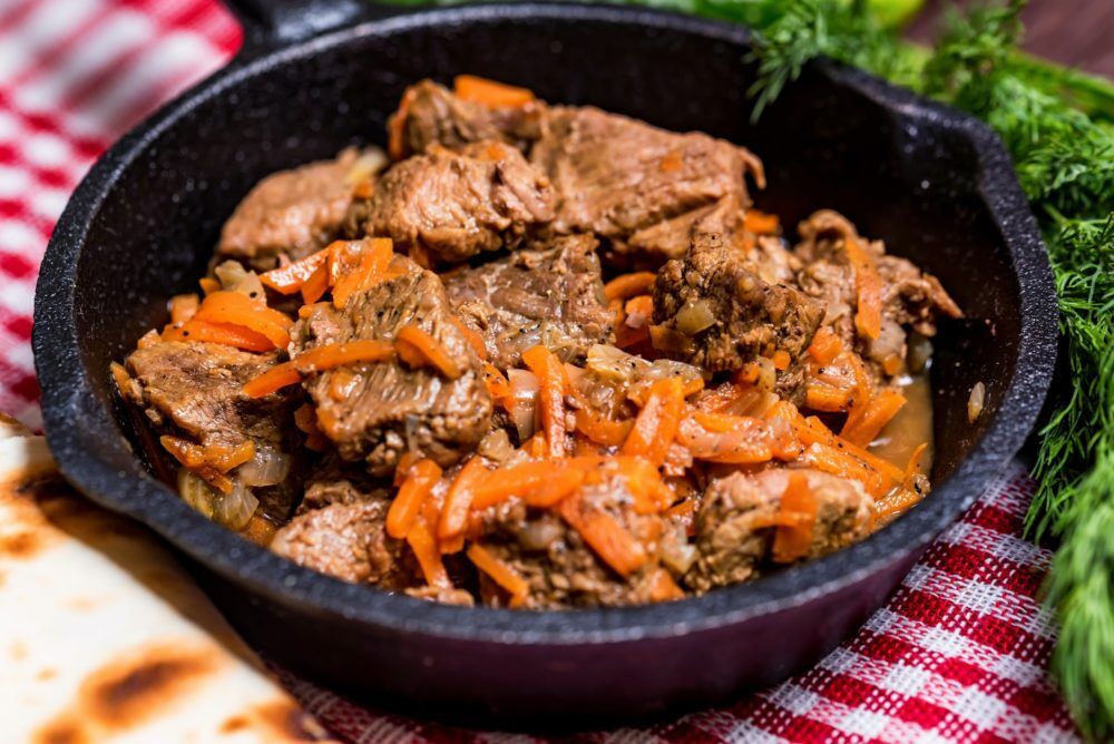 Beef stew in frying pan and vegetables